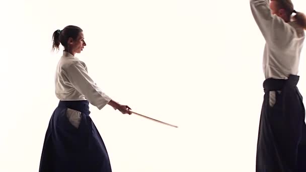 Mann og kvinne som øver på aikido med bokken. Isolert på hvitt. Lukk igjen. Langsom bevegelse . – stockvideo