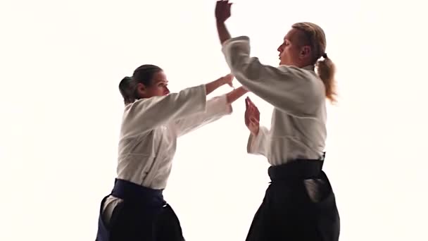 Homem e mulher em keikogi branco mostrando técnicas de aikido, isolado em branco. Fecha. Movimento lento . — Vídeo de Stock