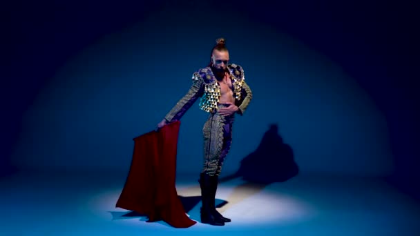 Torero in blue and gold suit or typical spanish bullfighter isolated spotlight on a blue background — 비디오