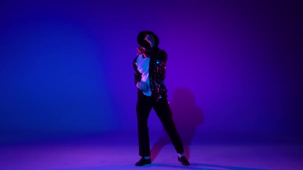 Jovem adolescente elegante está mostrando movimentos de dança como Michael Jackson. Isolado sobre fundo azul . — Vídeo de Stock