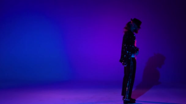 Giovane adolescente elegante sta mostrando mosse di danza come Michael Jackson. isolato su sfondo blu . — Video Stock