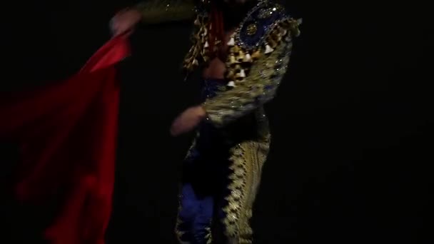 Torero in blue and gold suit or typical spanish bullfighter isolated spotlight on a black background. Close up, slow motion. — Stock Video