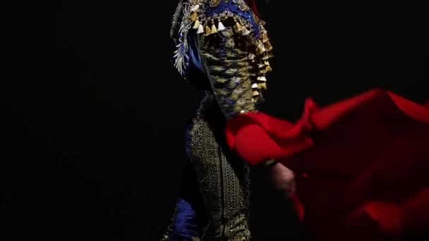 Torero in blue and gold suit or typical spanish bullfighter isolated spotlight on a black background. Close up, slow motion. — Stock Video