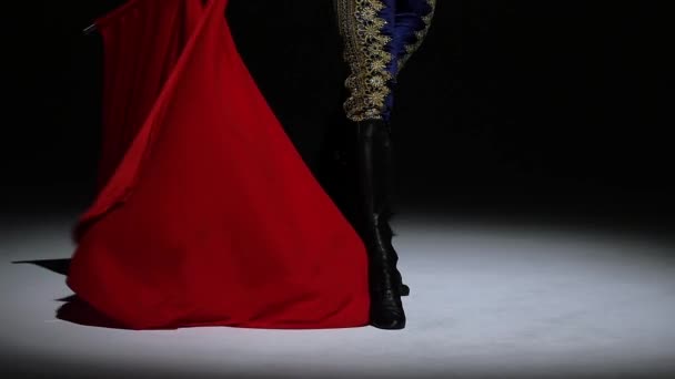 Torero in blauw en goud pak of typische Spaanse stierenvechter geïsoleerde schijnwerpers op een zwarte achtergrond. Sluiten van de benen, slow motion. — Stockvideo