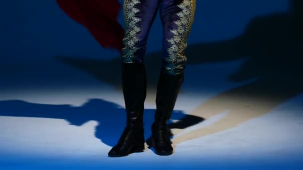 Torero im blau-goldenen Anzug oder typisch spanischer Stierkämpfer isoliert Scheinwerfer auf blauem Hintergrund. Nahaufnahme der Beine, Zeitlupe. — Stockvideo