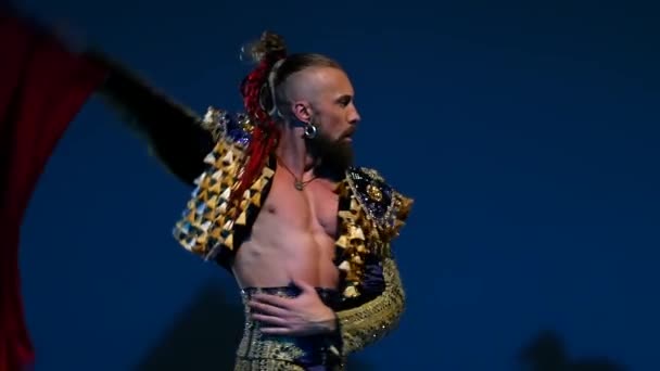 Torero in blue and gold suit or typical spanish bullfighter isolated spotlight on a blue background. Close up, slow motion. — ストック動画