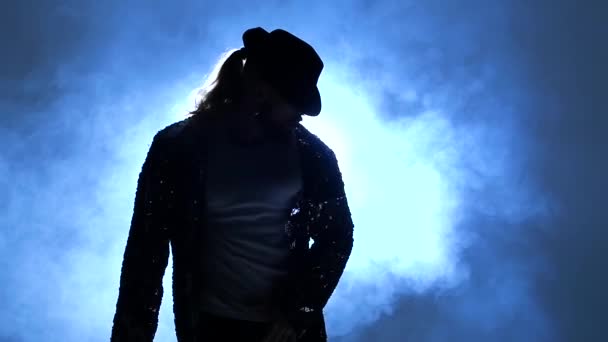 Genç bir dansçının silueti dumanın mavi arka planında Michael Jackson tarzında dans ediyor. Yaklaşın, ağır çekim.. — Stok video