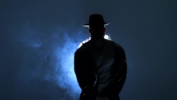 Silhueta de um jovem dançarino dançando com estilo Michael Jackson em um fundo azul de fumaça. Fecha, câmara lenta. . — Vídeo de Stock