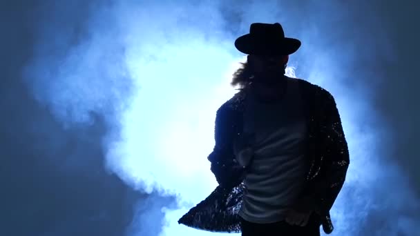 Genç bir dansçının silueti dumanın mavi arka planında Michael Jackson tarzında dans ediyor. Yaklaşın, ağır çekim.. — Stok video