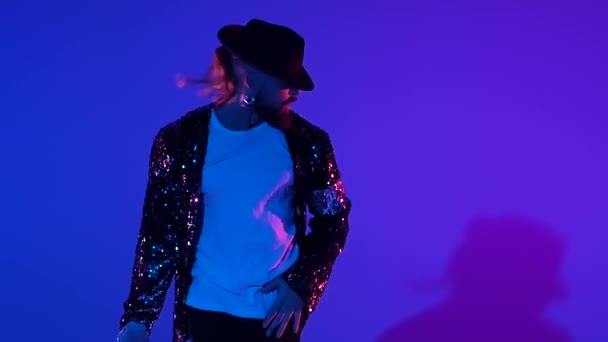 Homem elegante jovem dançando em estilo Michael Jackson, holofotes sobre um fundo azul. Fecha, câmara lenta. . — Vídeo de Stock