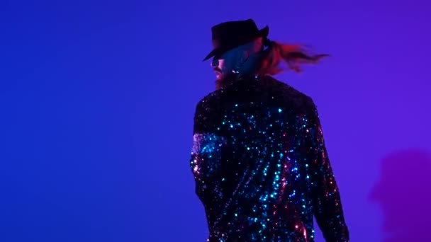 Junger stilvoller Mann, der im Stil von Michael Jackson tanzt, Scheinwerfer auf blauem Hintergrund. Nahaufnahme, Zeitlupe. — Stockvideo