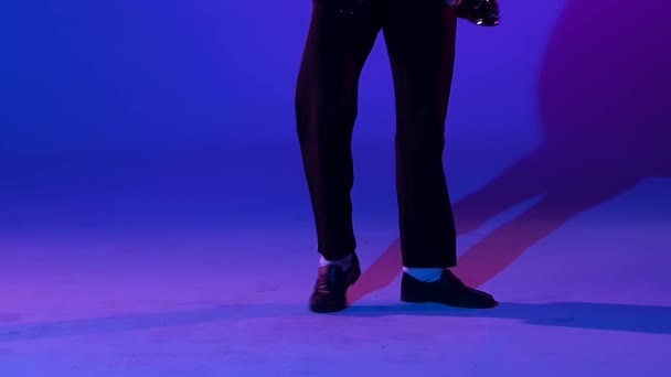 Young stylish man dancing in style Michael Jackson, spotlight on a blue background. Close up of legs, slow motion. — 비디오