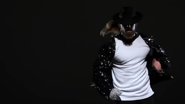Молодой стильный мужчина танцует в стиле Майкл Джексон, в центре внимания на черном фоне. Закройте, замедленная съемка . — стоковое видео
