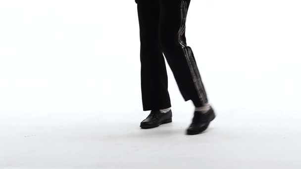 Young stylish teenager is showing dance moves like Michael Jackson. Isolated over white background. Close up of legs, slow motion. — Stock Video