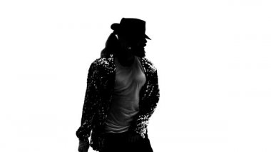 Beyaz arka planda Michael Jackson tarzı dans eden genç bir adamın silueti. Yaklaşın, ağır çekim..