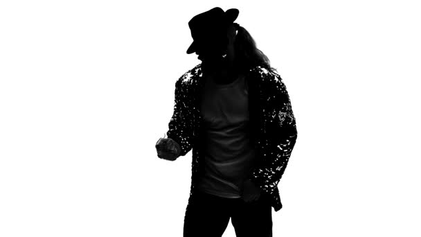 Silhouet van een jonge man danseres dansend in stijl Michael Jackson op witte achtergrond. Close up, slow motion. — Stockvideo