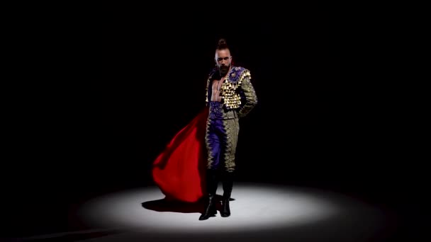 Torero in blue and gold suit or typical spanish bullfighter isolated spotlight on a black background. Close up, slow motion. — Stock Video