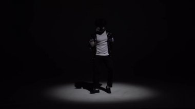 Tarz sahibi genç adam Michael Jackson, siyah arka planda spot ışıkları. Yaklaşın, ağır çekim..