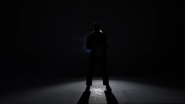 Silhouette eines jungen Mannes, der im Stil von Michael Jackson auf blauem Hintergrund aus Rauch tanzt. Nahaufnahme, Zeitlupe. — Stockvideo