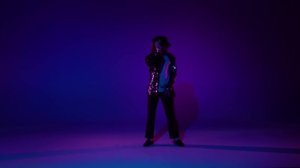 Homem elegante jovem dançando em estilo Michael Jackson, holofotes sobre um fundo azul. Fecha, câmara lenta. . — Vídeo de Stock