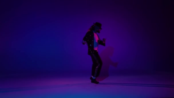 Joven hombre elegante bailando con estilo Michael Jackson, centro de atención sobre un fondo azul. Primer plano, cámara lenta . — Vídeo de stock