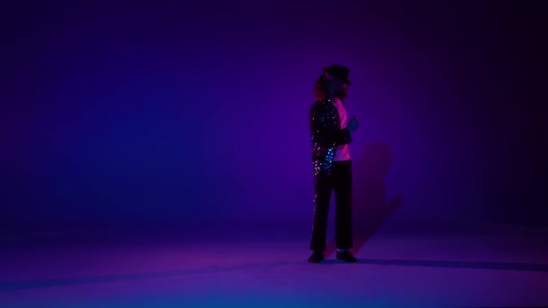 Jonge stijlvolle man dansend in stijl Michael Jackson, spotlight op een blauwe achtergrond. Close up, slow motion. — Stockvideo