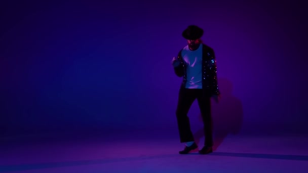 Ung snygg man dansar i stil Michael Jackson, spotlight på en blå bakgrund. Närbild, slow motion. — Stockvideo