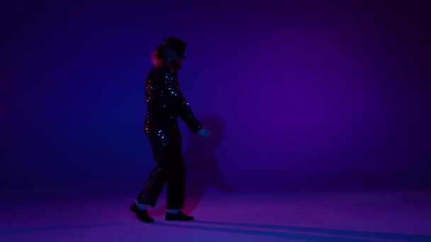 Joven hombre elegante bailando con estilo Michael Jackson, centro de atención sobre un fondo azul. Primer plano, cámara lenta . — Vídeos de Stock