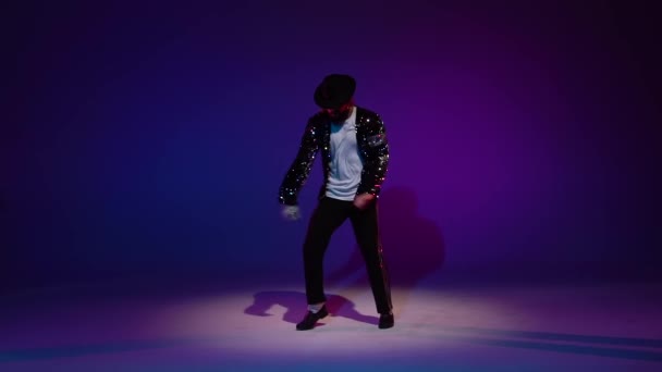 Jonge stijlvolle man dansend in stijl Michael Jackson, spotlight op een blauwe achtergrond. Close up, slow motion. — Stockvideo