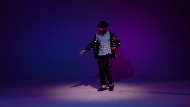 Mladý stylový muž tančící stylově Michael Jackson, reflektor na modrém pozadí. Zavřít, zpomalit.. — Stock video