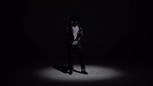 Homem elegante jovem dançando em estilo Michael Jackson, holofotes sobre um fundo preto. Fecha, câmara lenta. . — Vídeo de Stock