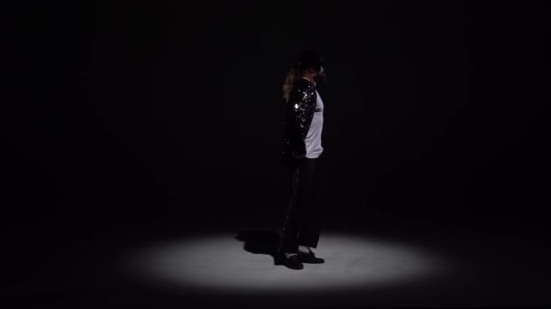 Joven hombre elegante bailando con estilo Michael Jackson, centro de atención sobre un fondo negro. Primer plano, cámara lenta . — Vídeos de Stock