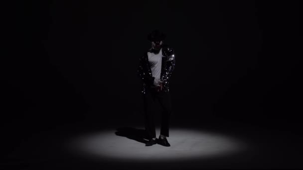 Joven hombre elegante bailando con estilo Michael Jackson, centro de atención sobre un fondo negro. Primer plano, cámara lenta . — Vídeo de stock
