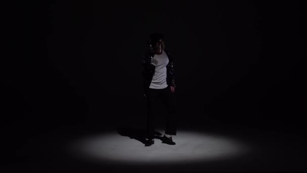 Young stylish man dancing in style Michael Jackson, spotlight on a black background. Close up, slow motion. — 비디오