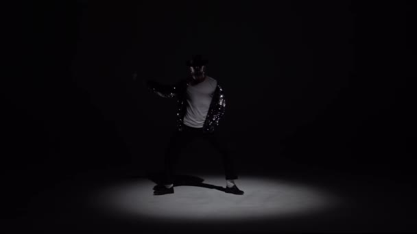 Mladý stylový muž tančící stylově Michael Jackson, reflektor na černém pozadí. Zavřít, zpomalit.. — Stock video