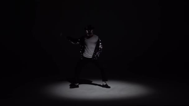 Homem elegante jovem dançando em estilo Michael Jackson, holofotes sobre um fundo preto. Fecha, câmara lenta. . — Vídeo de Stock