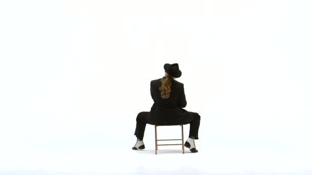 Κομψός άντρας με μαύρο καπέλο χορεύει ερωτικό χορό. Χρησιμοποιεί μια καρέκλα και ένα τσιγάρο. Λευκό φόντο. Κλείσιμο, αργή κίνηση. — Αρχείο Βίντεο