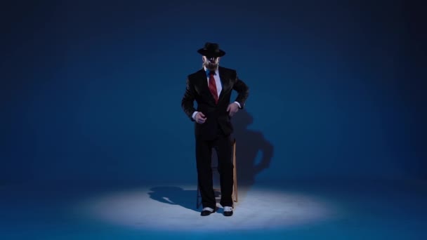 Elegantní muž v černém klobouku tančí erotický tanec. Spotlight na modrém pozadí. Zavřít, zpomalit.. — Stock video
