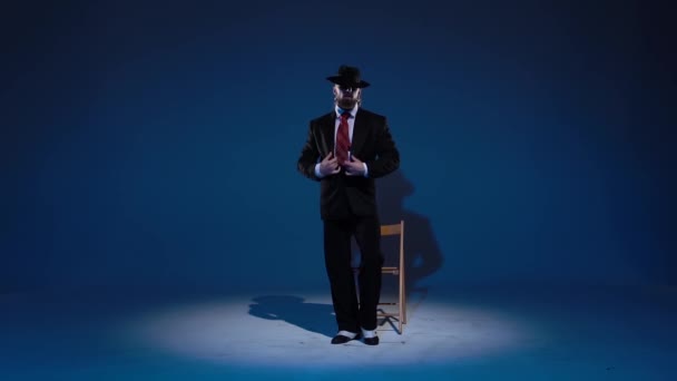 Az elegáns férfi fekete kalapban erotikus táncot jár. Spotlight kék háttérrel. Bezárás, lassított felvétel.. — Stock videók