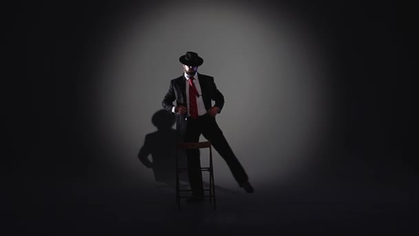 Elegant man i svart hatt dansar erotisk dans. Spotlight på en svart bakgrund. Närbild, slow motion. — Stockvideo