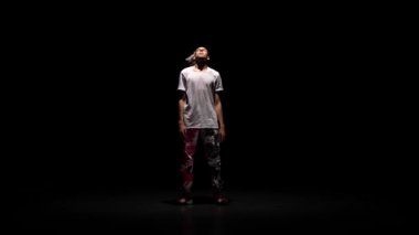 Profesyonel genç hip-hop dansçısı, sisin içinde karanlık stüdyoda dans ediyor. Hip hop kültürü. Prova. Çağdaş.