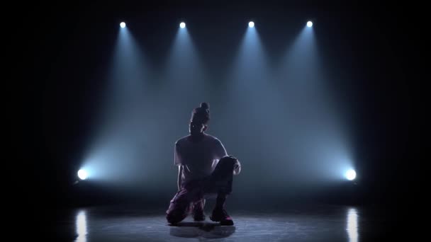 Hombre disfrutando de movimientos de hip hop en estudio oscuro con humo e iluminación . — Vídeo de stock