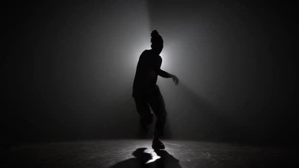 Sziluett fiatalember, aki egyedül táncol a klubban, neonfény, sok füst. Divat utcai viselet. Sziluett. — Stock videók