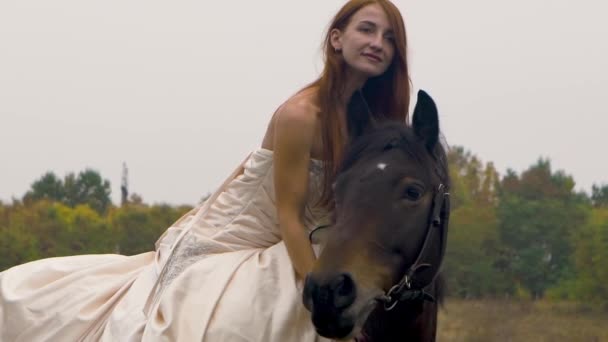 Ginger horsewoman in poofy dress riding horse on meadow. Close-up — 비디오