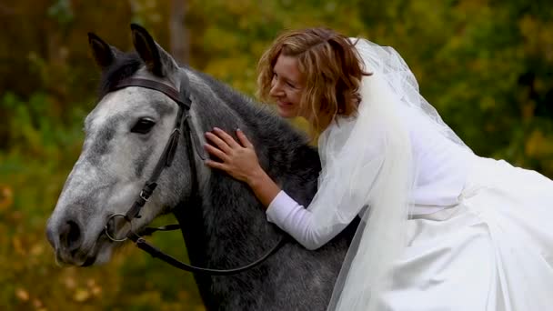 Horsewoman in poofy wedding dress is stroking horse. Close up — Stock Video