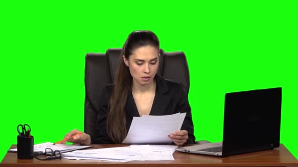 Gestresste Frau liest Dokument durch und wirft zerknülltes Papier vom Tisch. Green Screen. Zeitlupe — Stockvideo