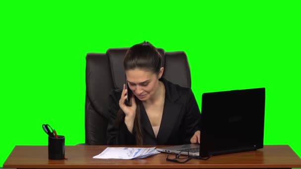 ノートパソコンで仕事をし、電話で楽しく話す女性。緑の画面だスローモーション — ストック動画