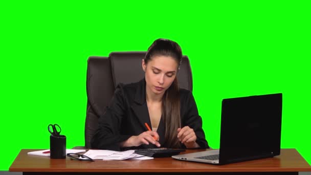 工作场所的女商人从事财务工作，用计算器进行计算并填写文件。 绿色屏幕。 慢动作 — 图库视频影像