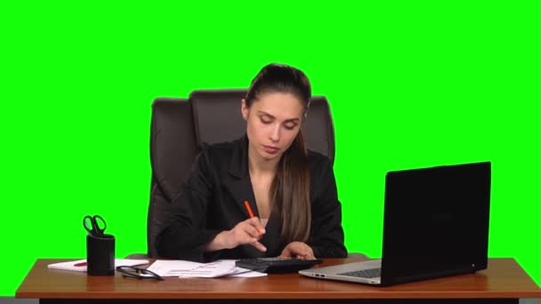 Geschäftsfrau am Arbeitsplatz beschäftigt sich mit Finanzen, macht Berechnungen auf einem Taschenrechner und füllt Papiere aus. Green Screen. Zeitlupe — Stockvideo