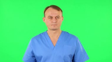 Sağlıkçı etrafına bakar, eliyle ağzını kapatır ve sırrı fısıldar ve sessiz bir jest yapar. Yeşil Ekran